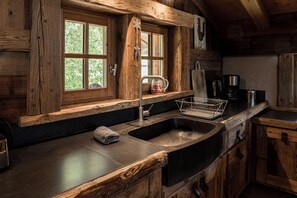 A kitchen with wooden cabinetry, a double sink, and a coffee maker. - Exceptional "Frachette" Chalet (Praz-Sur-Arly)