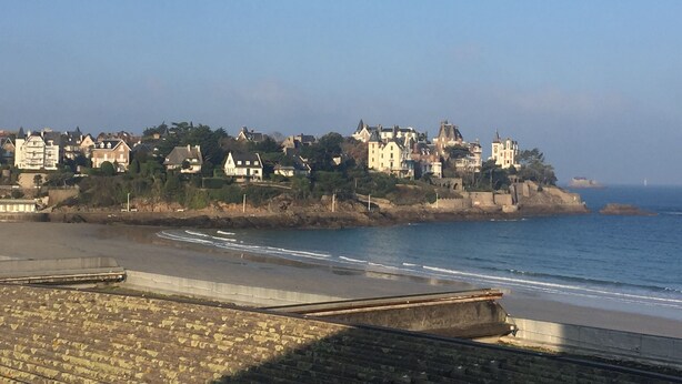 A coastal town with historic buildings and a beach.