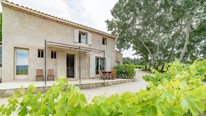 Une maison de campagne avec un patio, une table et des chaises.