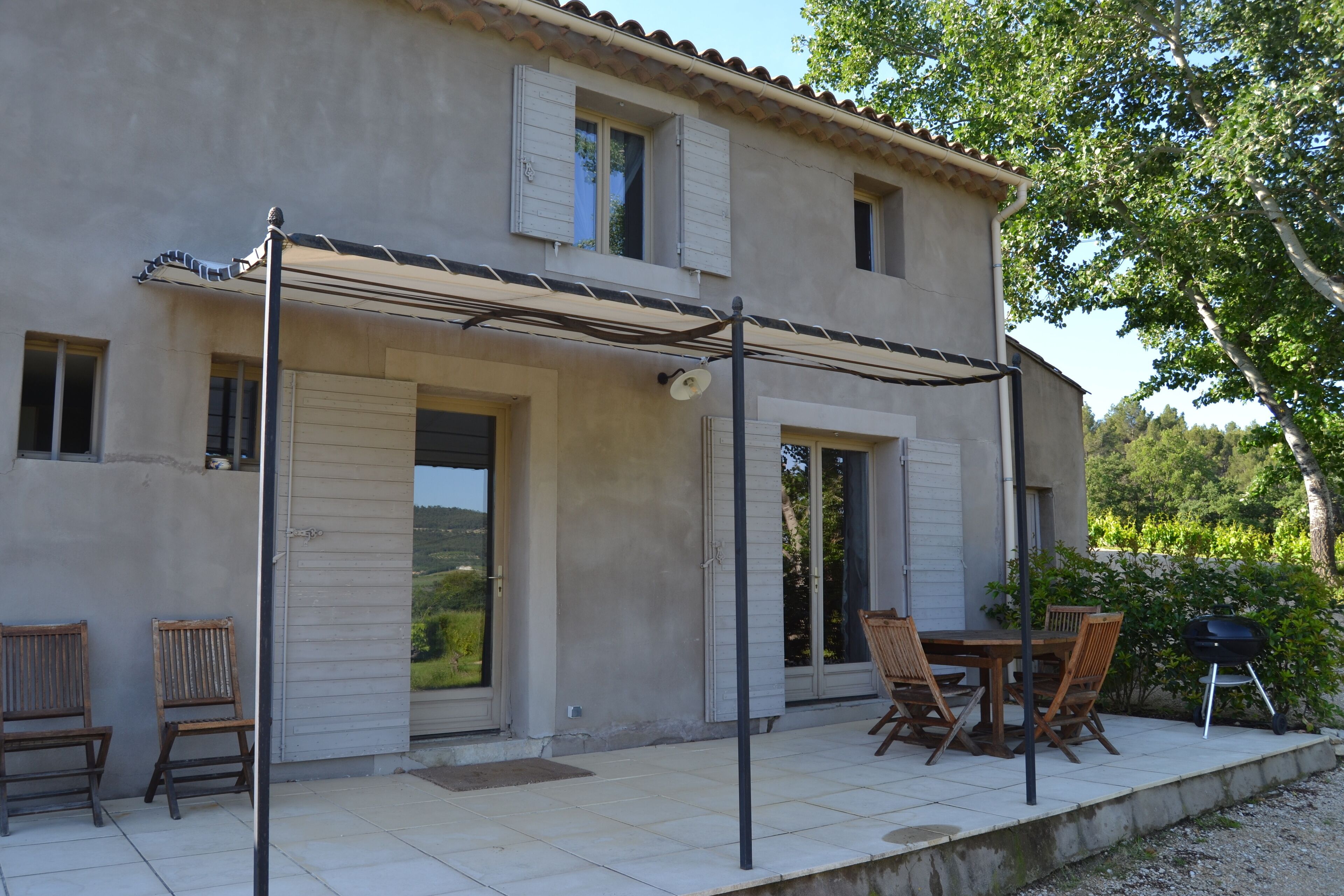 A two-story house with a covered patio area.