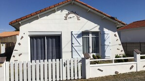 A single-story building with a white facade, a red-tiled roof, and a white picket fence. - INDEPENDENT HOUSE CLOSE TO SEA AND PORT LA GRAVETTE 50 M (La Plaine-sur-Mer)