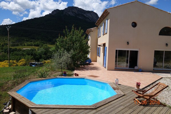 Relax on the deck with a lounge chair, surrounded by a serene pool and breathtaking mountain views.