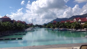 Uma marina com barcos, piscina e edifícios com telhados vermelhos.