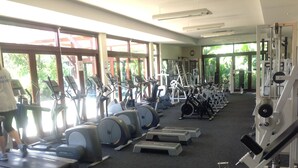 Academia com esteiras, bicicletas ergométricas e aparelhos de musculação.