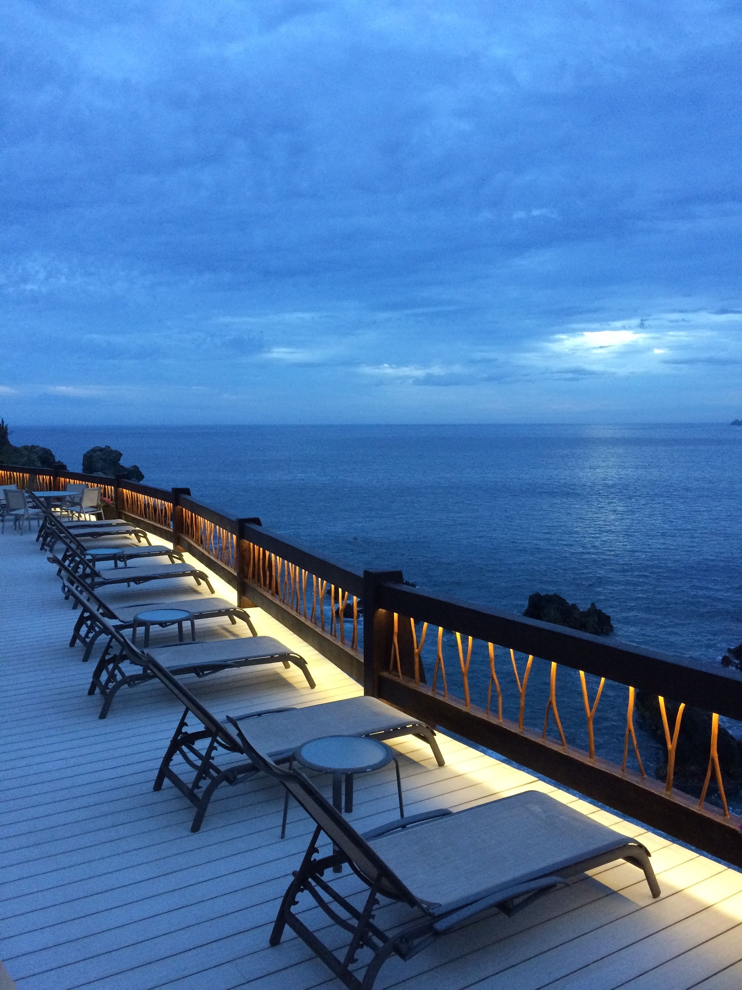 One of the pool decks overlooking the ocean at nightfall