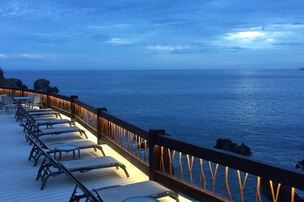 One of the pool decks overlooking the ocean at nightfall