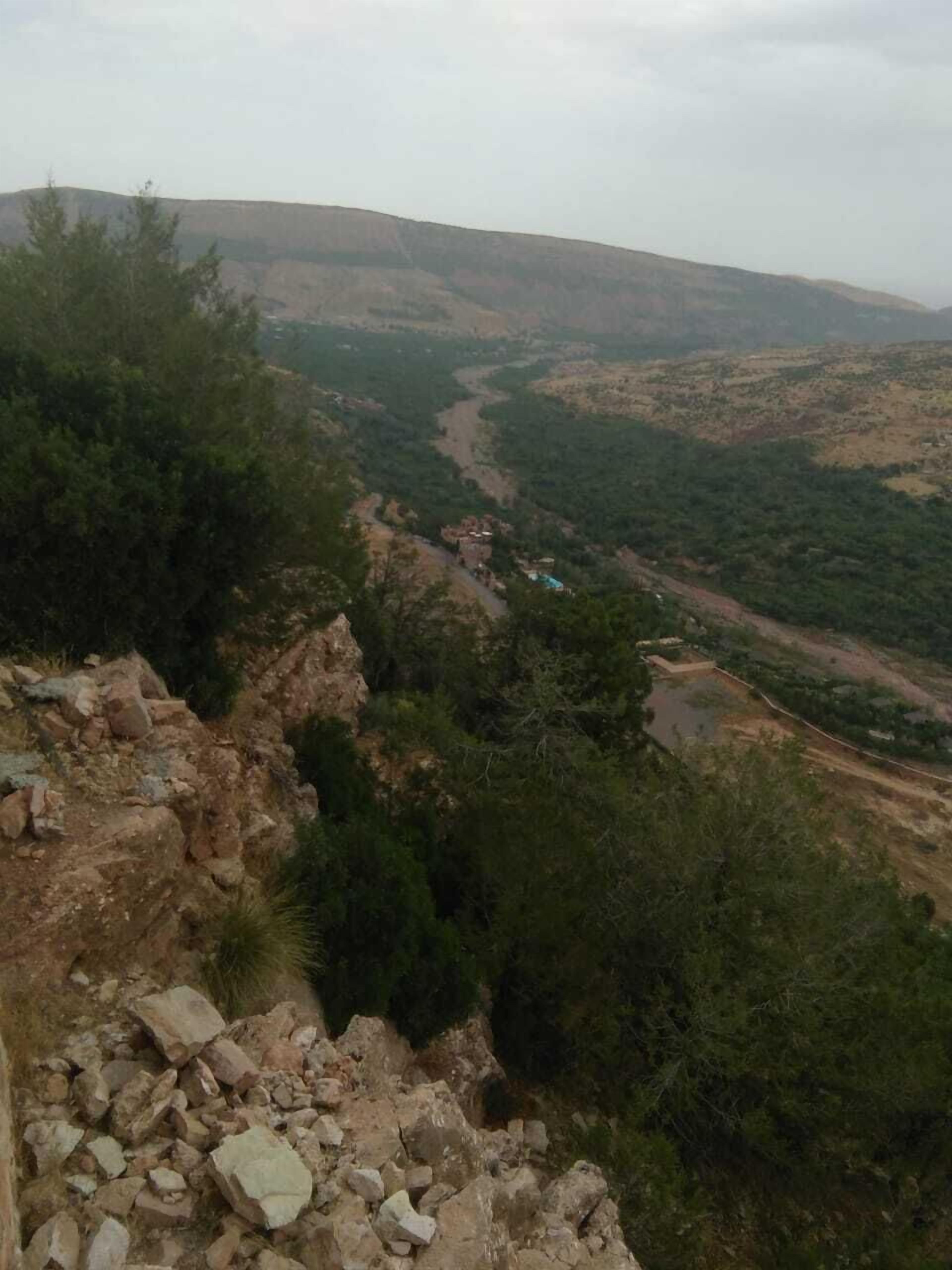 A rugged landscape with a river, rocky terrain, and sparse vegetation.