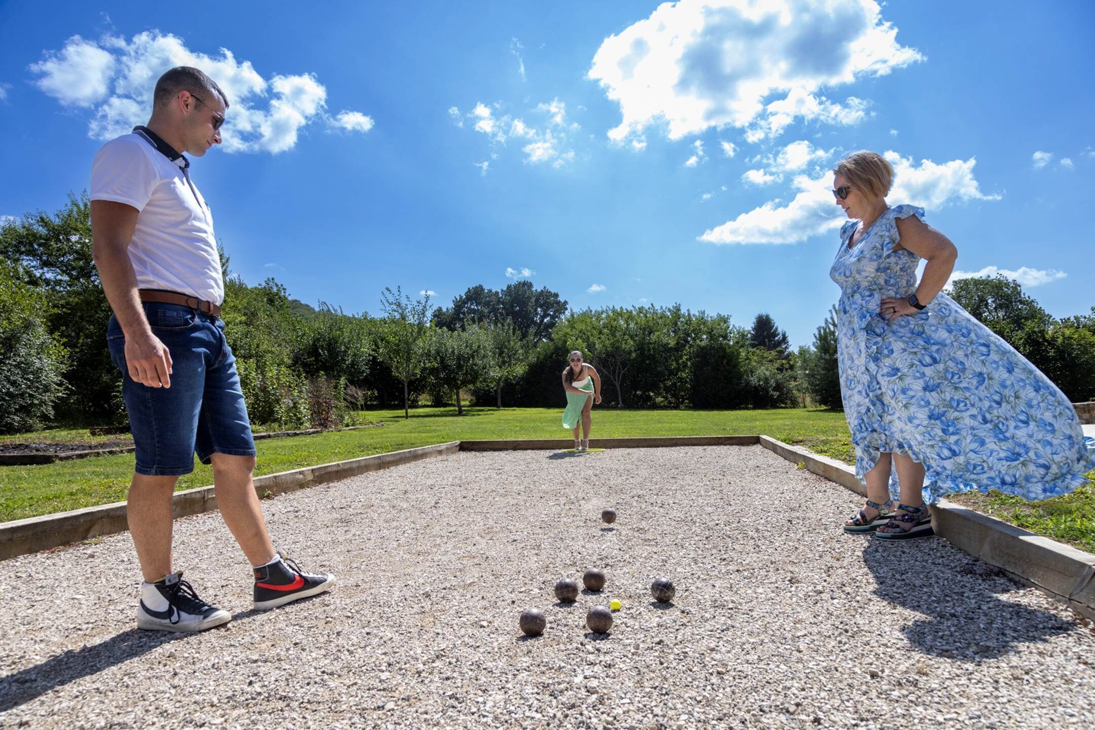 A courtyard with a lawn, a gravel area, and a few people.