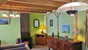 Un salon chaleureux avec une cheminée, des meubles en bois et des œuvres d’art accrochées aux murs.