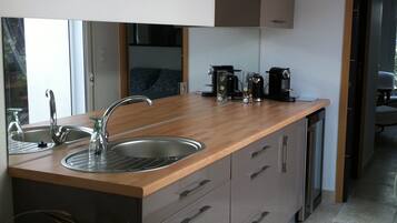 A modern kitchen with a wooden countertop, stainless steel sink, and built-in cabinets.