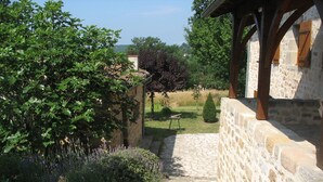 Un sentier de pierres mène à un bâtiment rustique doté de poutres en bois et de murs en pierre.
