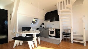 A modern kitchen with a dining area, a staircase, and a view of the outside. - COUP DE ❤️ LA MOUETTE DEAUVILLAISE🐦classified 4☆ Tennis-Pool-Parking-Linen-Wifi (DEAUVILLE)