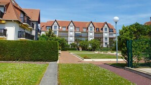 A residential building with a symmetrical facade, multiple balconies, and a well-maintained garden area. - COUP DE ❤️ LA MOUETTE DEAUVILLAISE🐦classified 4☆ Tennis-Pool-Parking-Linen-Wifi (DEAUVILLE)