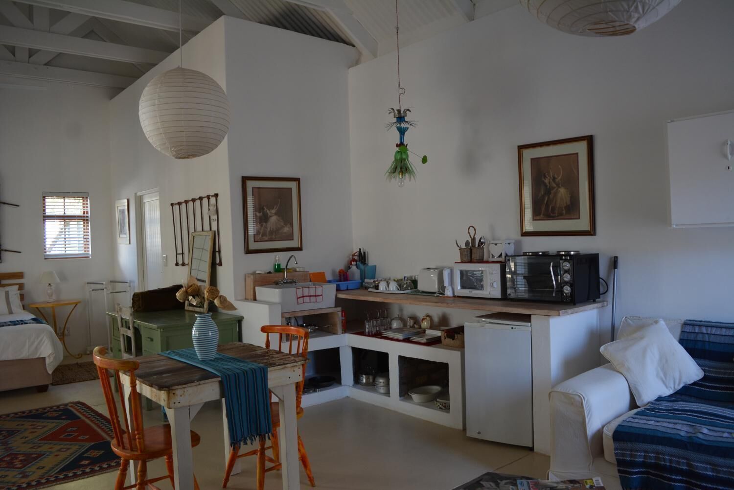 Un espacio habitable compacto con kitchenette, comedor y zona de estar.