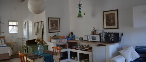 Un espacio habitable compacto con kitchenette, comedor y zona de estar.