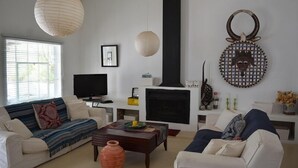Un soggiorno con camino, divani, televisore e oggetti decorativi.
