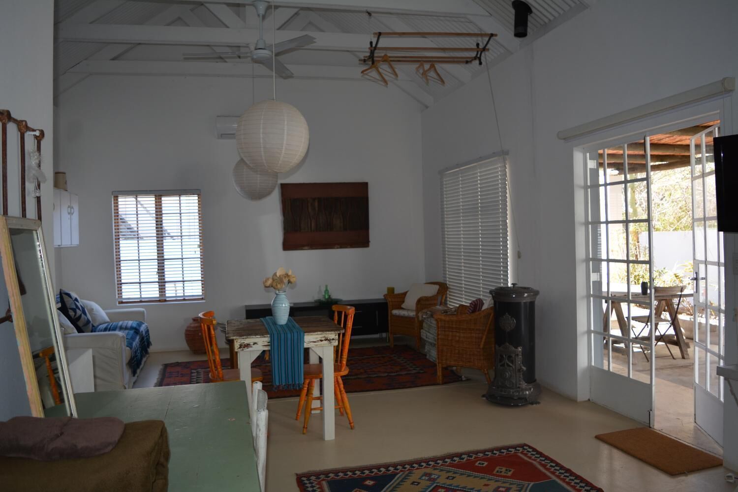 A spacious room with a dining area, a large window, and a view of the outdoors.