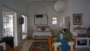 Una camera da letto con un letto, comodini, una scrivania, una sedia, un tappeto e una lampada a sospensione.