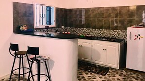 A compact kitchen with a central island, white cabinets, and a patterned backsplash. - Dar AESHA (Without Vis à Vis) (Djerba)