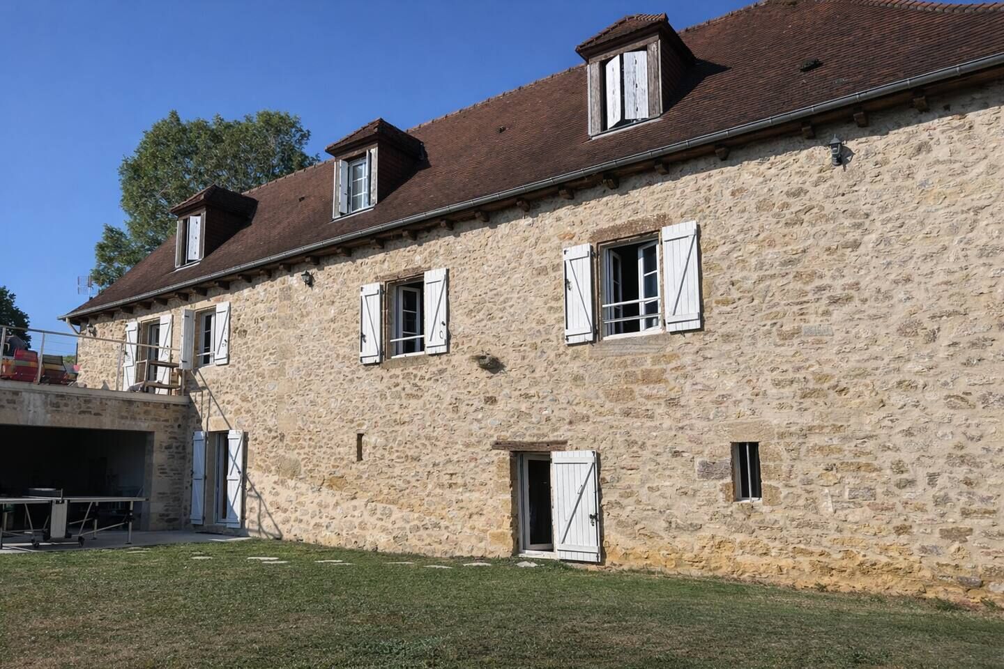 A stone building with multiple windows and a small door.