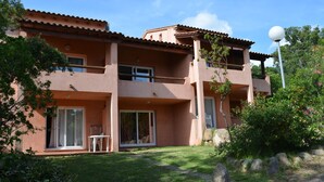 A two-story building with a flat roof, large windows, and a balcony. - Duplex for 5 people, 500m from the beach in a residence with swimming pool (Sainte-Lucie de Porto-Vecchio)