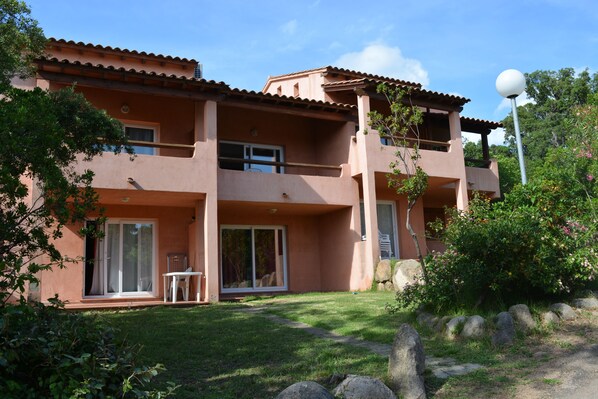 A two-story building with a flat roof, large windows, and a balcony.