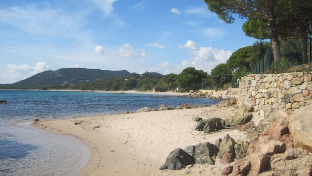 A beach with a stone wall and rocky shoreline. - Duplex for 5 people, 500m from the beach in a residence with swimming pool (Sainte-Lucie de Porto-Vecchio)