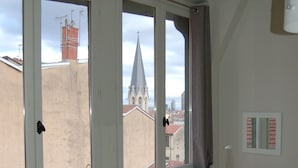 A room with a large window, a radiator, a small table, and a lamp.