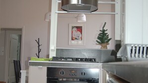 A kitchen with a built-in oven, a stove, and a microwave. There is a small potted plant on the counter.