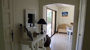 Ein Flur mit einer weißen Konsole, einer Lampe und einem Bild an der Wand.