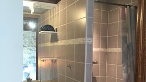 A bathroom with a shower, a sink, and a mirror. - quercy stone guest rooms decorated with taste. (PORTE-DU-QUERCY)