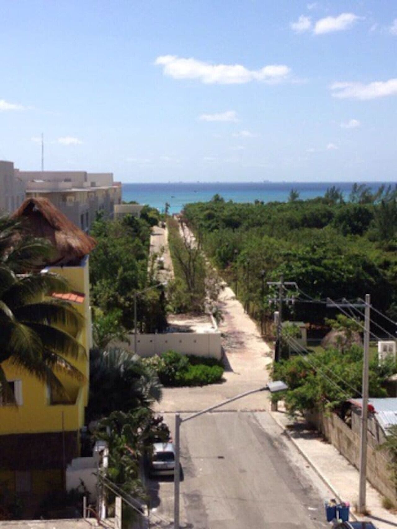 A street with buildings on one side and a beach on the other.