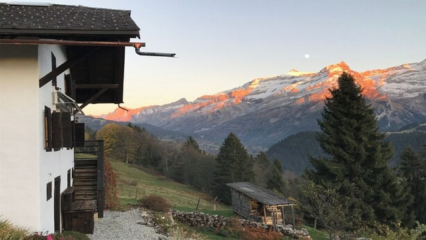 A mountain cabin with a wooden staircase and a small shed, surrounded by trees and a mountain range. - ✨CHALET WITH A CINEMATIC VIEW  (Ormont-Dessus)
