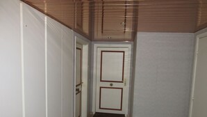 Un couloir étroit avec un plafond en bois et une porte au fond.