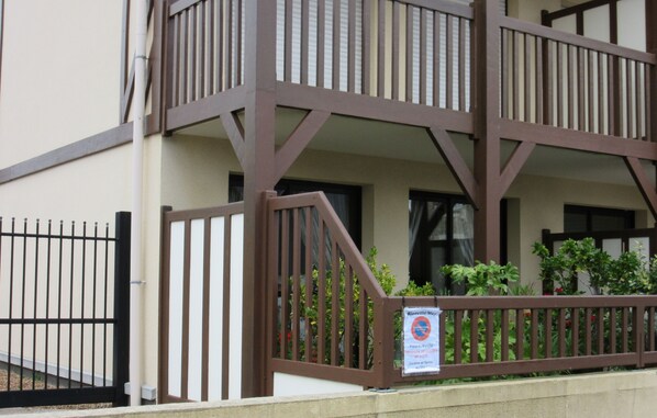 A multi-story building with a balcony and a sign indicating no parking.