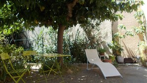 Un giardino con un tavolo, una sedia e un albero.