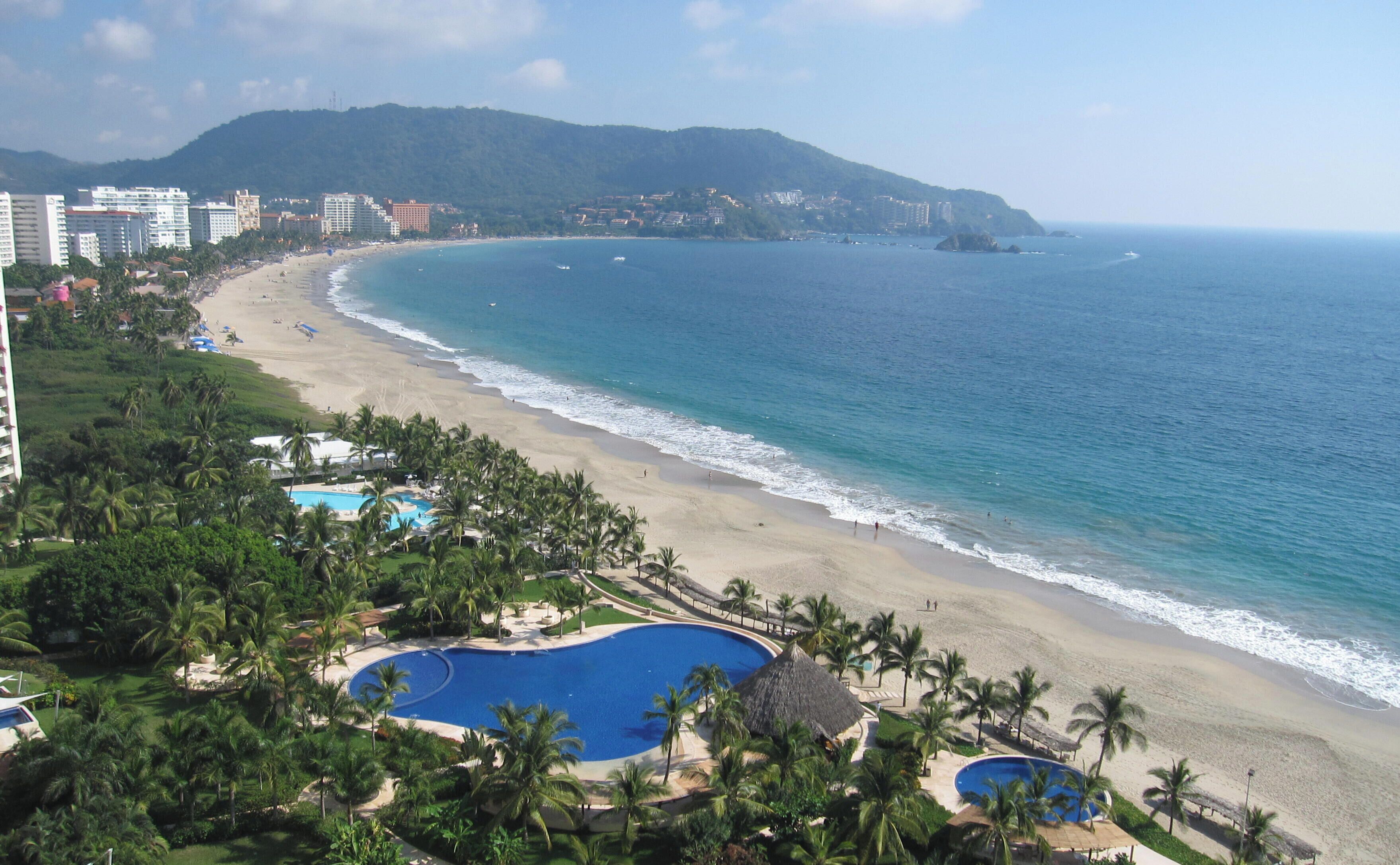 Un complexe hôtelier doté d’une grande piscine, d’un accès à la plage et offrant une vue sur l’océan.