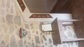 Features a decorative metal plaque and a metal-framed window with a tiled floor.