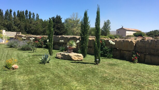 Um jardim bem cuidado com diversas plantas e um muro de pedra.