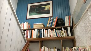 A narrow staircase with bookshelves on either side, a framed picture on the wall, and a blue wall. - Charming house, enclosed garden facing south, sheltered from the wind! (Arzon)