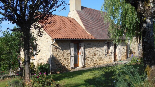 A stone house with a tiled roof, a chimney, and a small garden with flowers and shrubs. - perigourdine house in the countryside (saint germain de belves)