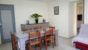 A dining area with a glass table, wooden chairs, a potted plant, and a cabinet. - perigourdine house in the countryside (saint germain de belves)