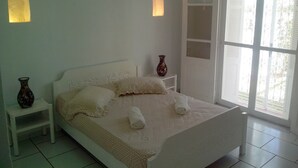 A bedroom with a bed, bedside tables, and a window with a view. - Ideal for holidays (NABEUL)