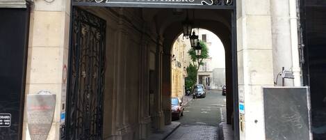 A stone archway with intricate carvings and a metal gate labeled "CITE MONTHERS".