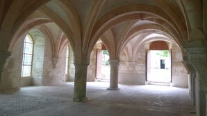 An interior with arched ceilings and columns, stone walls, and a brick floor. - Near the castle of the Count of Bussy Rabutin (historical monument) studio 4 p (Bussy-Le-Grand)