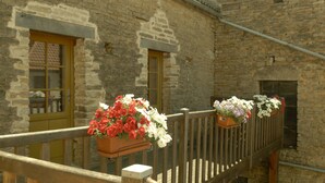 A stone building with two windows and a wooden balcony railing. - Near the castle of the Count of Bussy Rabutin (historical monument) studio 4 p (Bussy-Le-Grand)