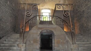 A stone staircase with ornate metal railings and a natural light source at the top. - Near the castle of the Count of Bussy Rabutin (historical monument) studio 4 p (Bussy-Le-Grand)