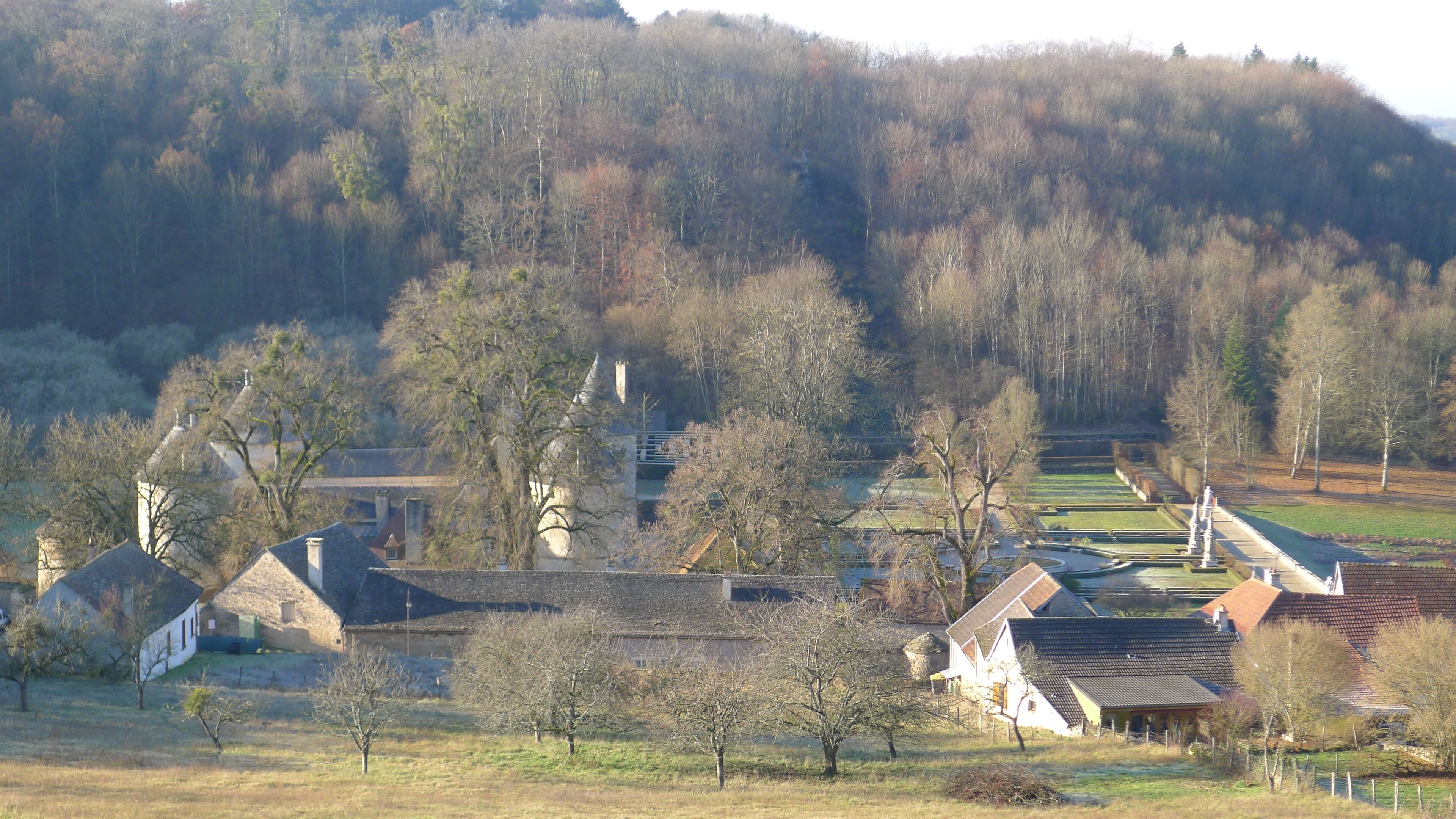 A rural village with traditional houses, a church, and a hill in the background.