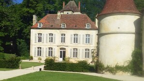 A large, historic building with a central tower and symmetrical windows, surrounded by a well-maintained lawn. - Near the castle of the Count of Bussy Rabutin (historical monument) studio 4 p (Bussy-Le-Grand)