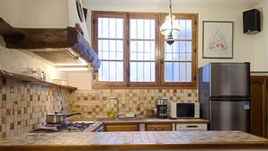 A kitchen with a tiled backsplash, a stove, a sink, a microwave, and a refrigerator. - Apartment in the heart of the village (Puget-Théniers)